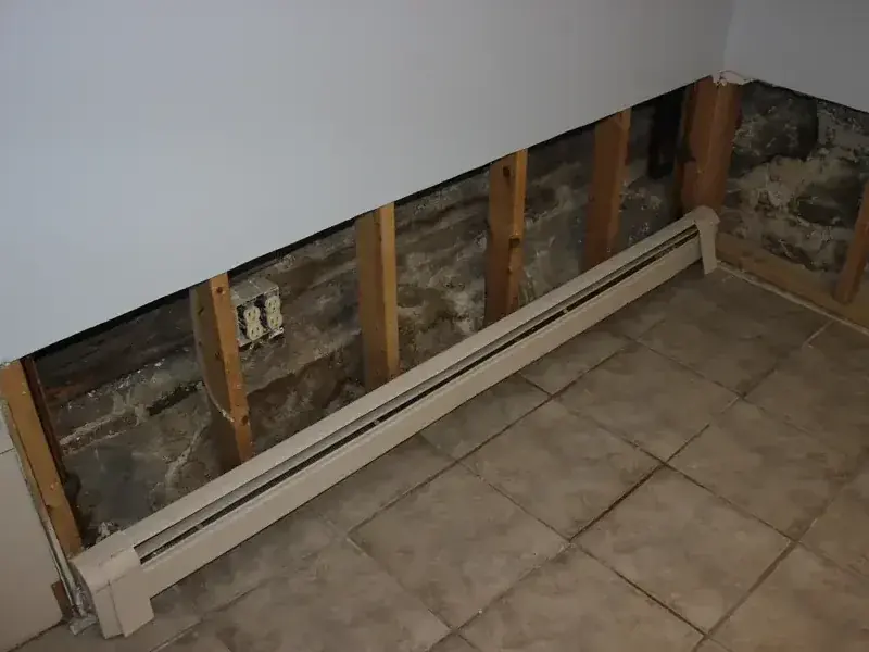 Drywall cut back above a baseboard heater during structural drying