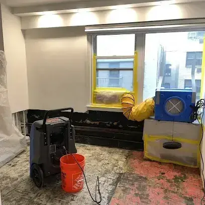 Dehumidifier and air mover drying a stripped room, typical of Milwaukie jobs