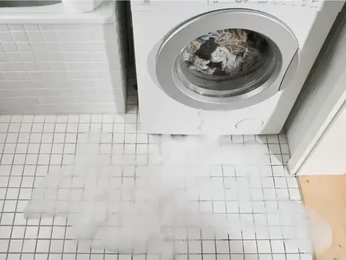 Water running across a floor from a failed appliance supply hose